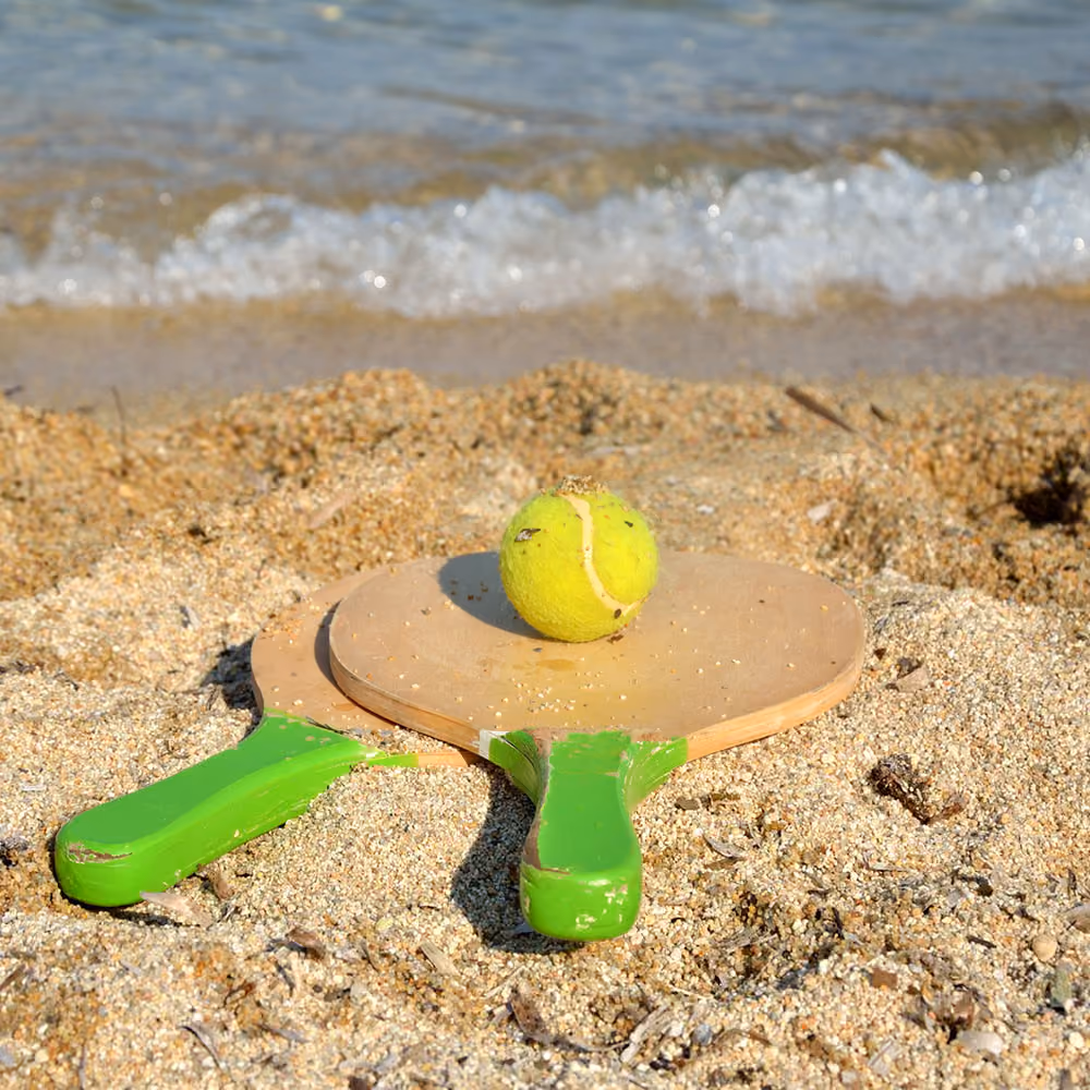 Pair of rackets and ball for sport on the beach